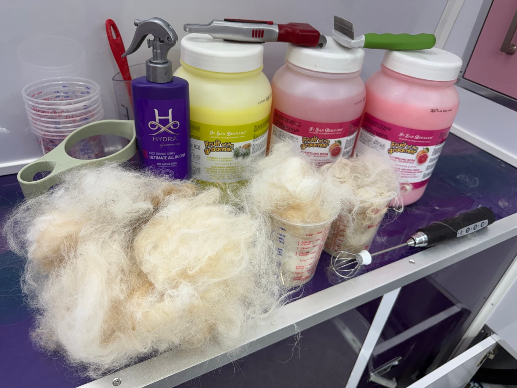 ISB grooming products, tools, and brushed-out coat on Jamie's grooming cart